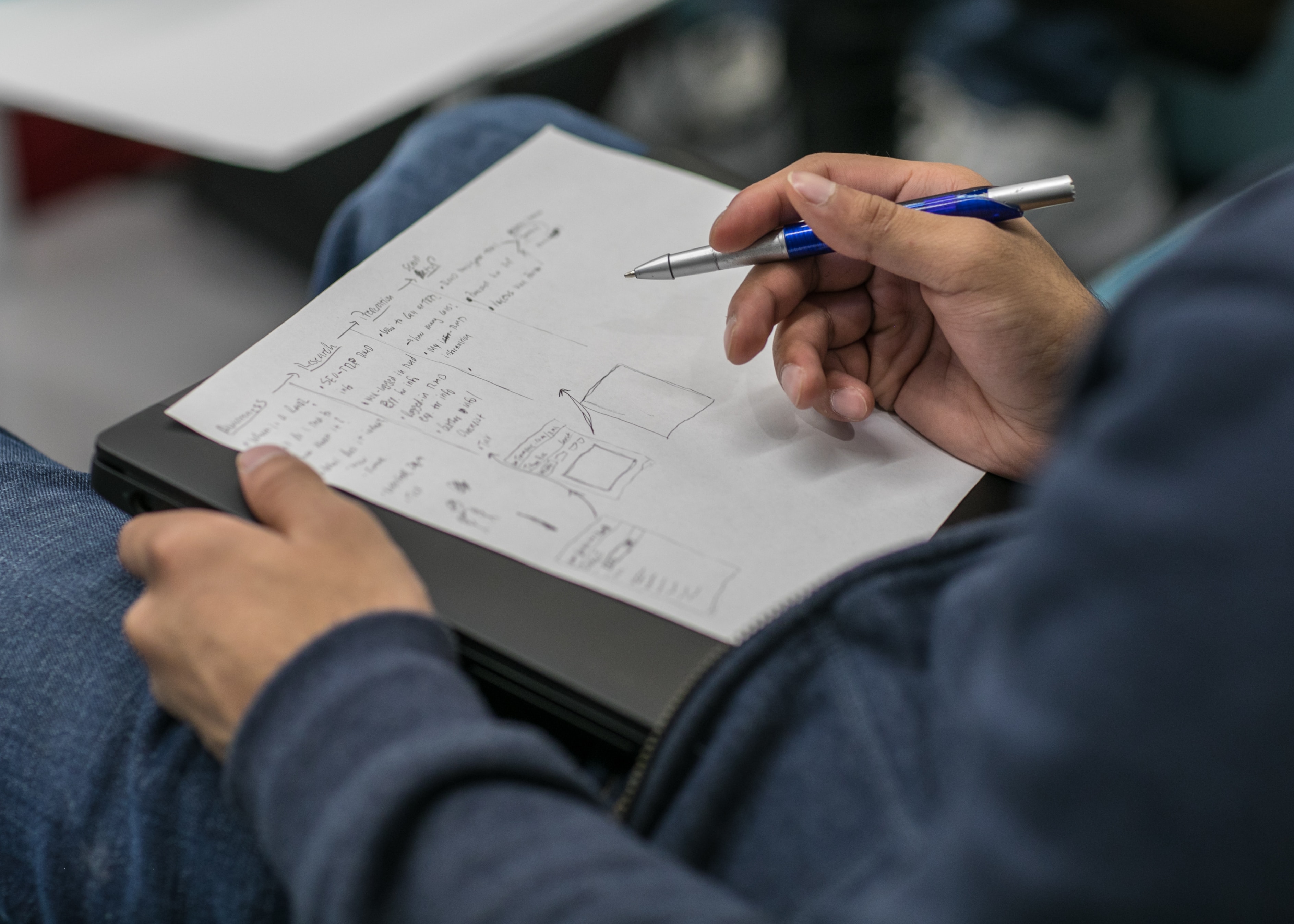 A student writing notes on a piece of paper
